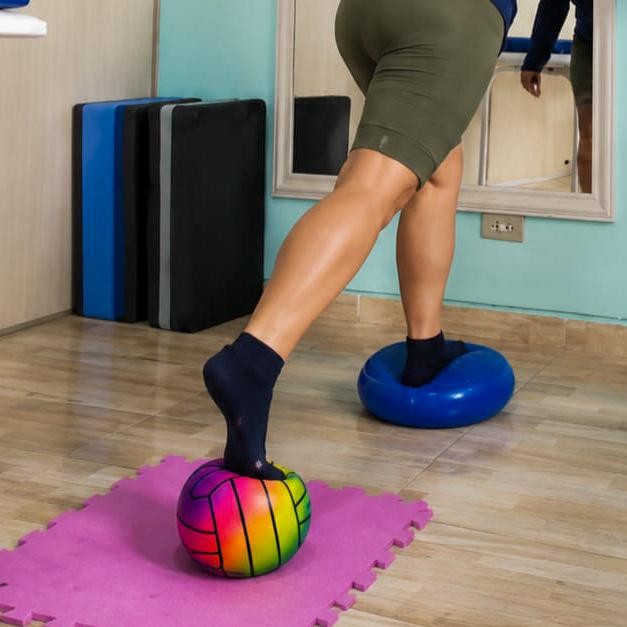 Paciente realizando exercício de equilíbrio sobre superfície instável